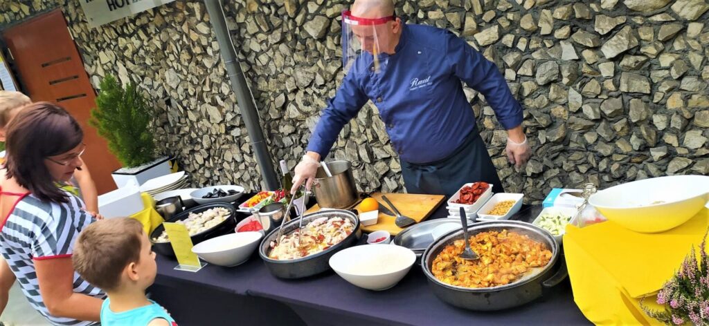 Kucharz przy stanowisku live cooking przygotowuje danie dla gości