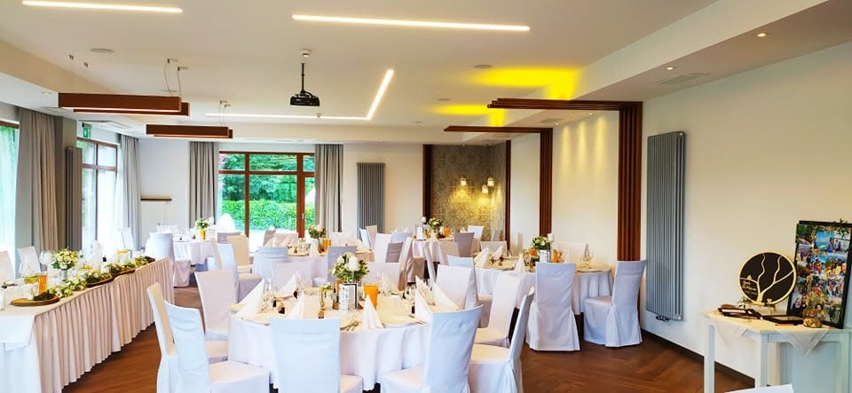Sala z okrągłymi stołami w bieli przygotowana na przyjęcie