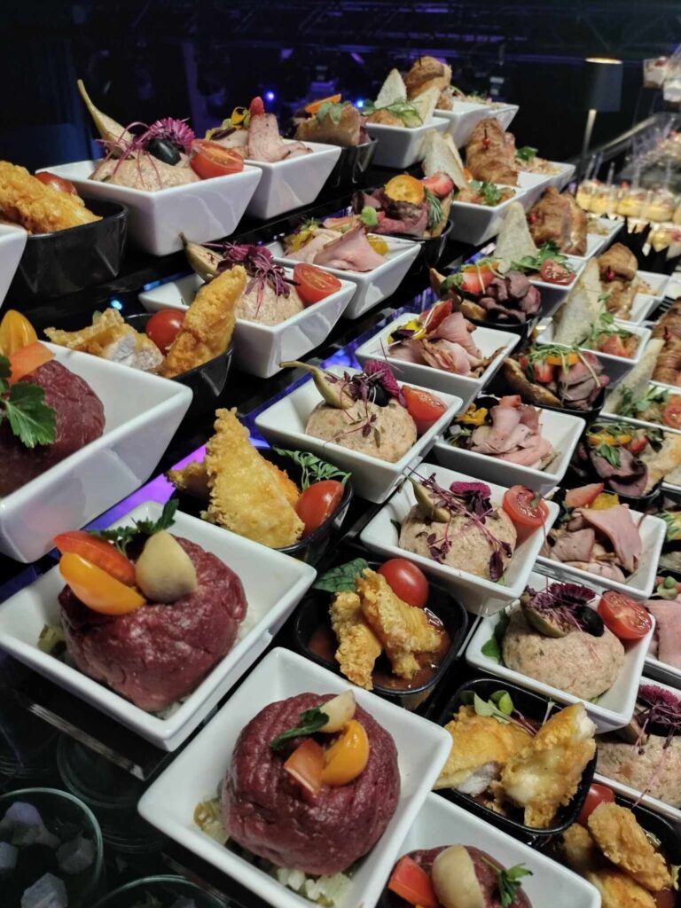 Rzad bialych miseczek z przekaskami - tatar, tempura, wedliny i swieze warzywa